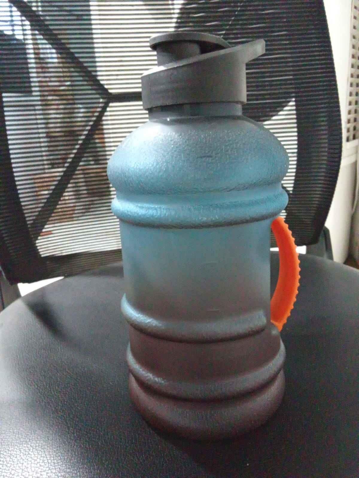 Reusable fitness water jug with textured body and orange handle for easy grip by THE GIR FARMER
