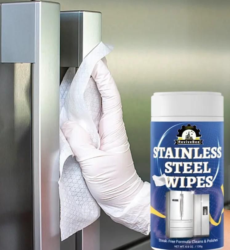 Hand using stainless steel wipes for fridge and appliances to clean stainless steel refrigerator handle