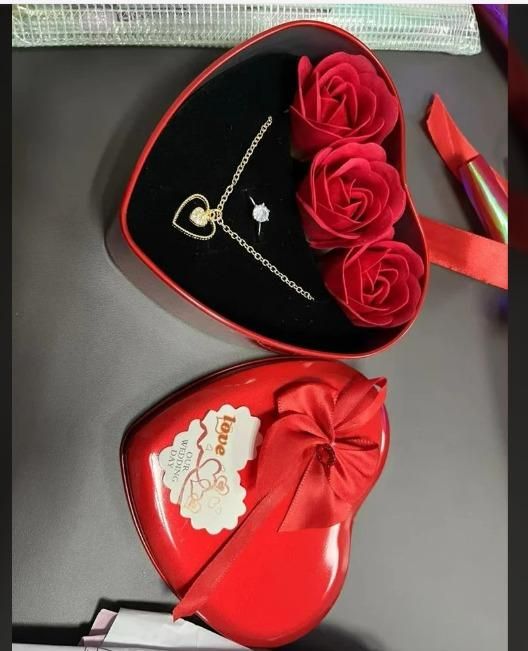 Romantic jewelry and flower combo with heart-shaped necklace and red roses in heart-shaped gift box
