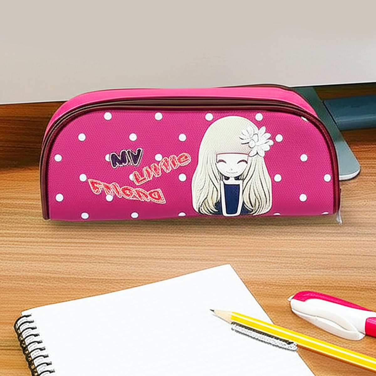 Pink school pencil case for children with cartoon girl and white polka dots on a wooden desk