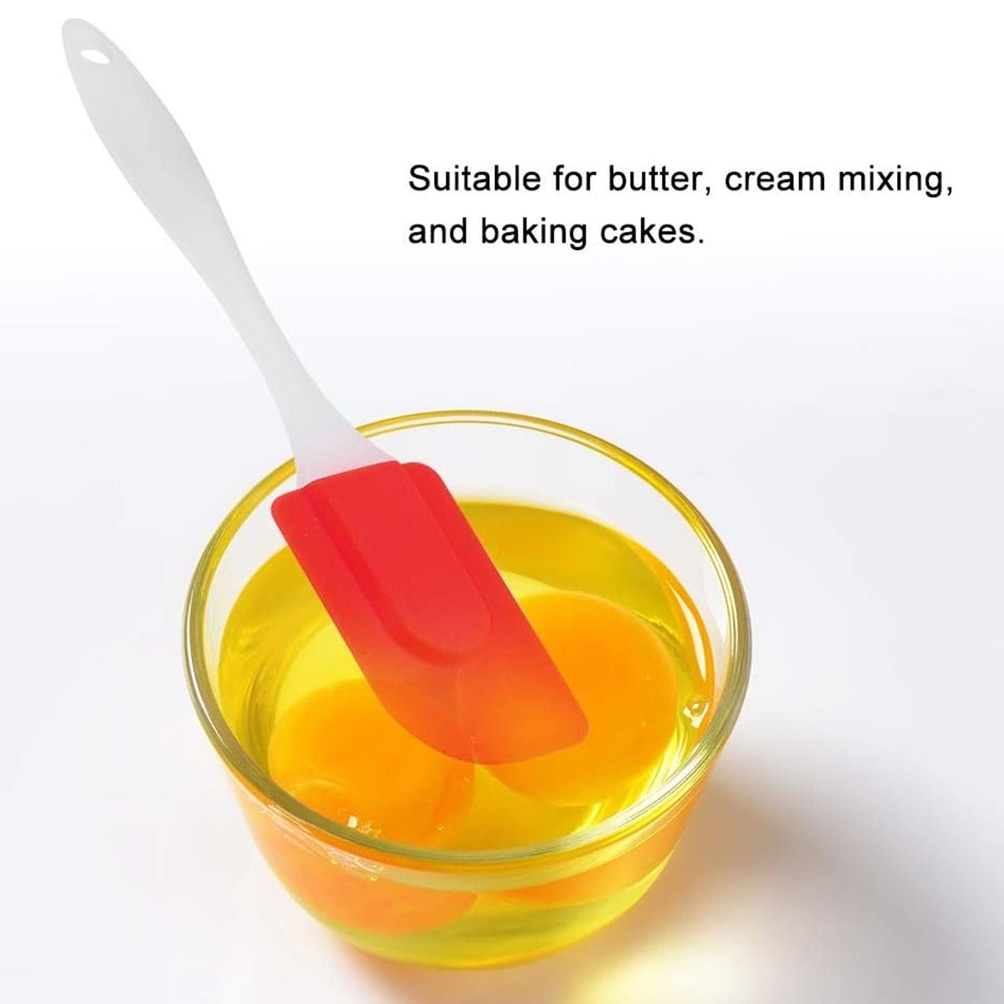 Red and white silicone baking spatula in a bowl for mixing butter and cream