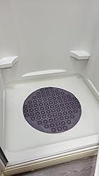 Purple silicone foot massage pad with circular nodes placed inside a white shower base