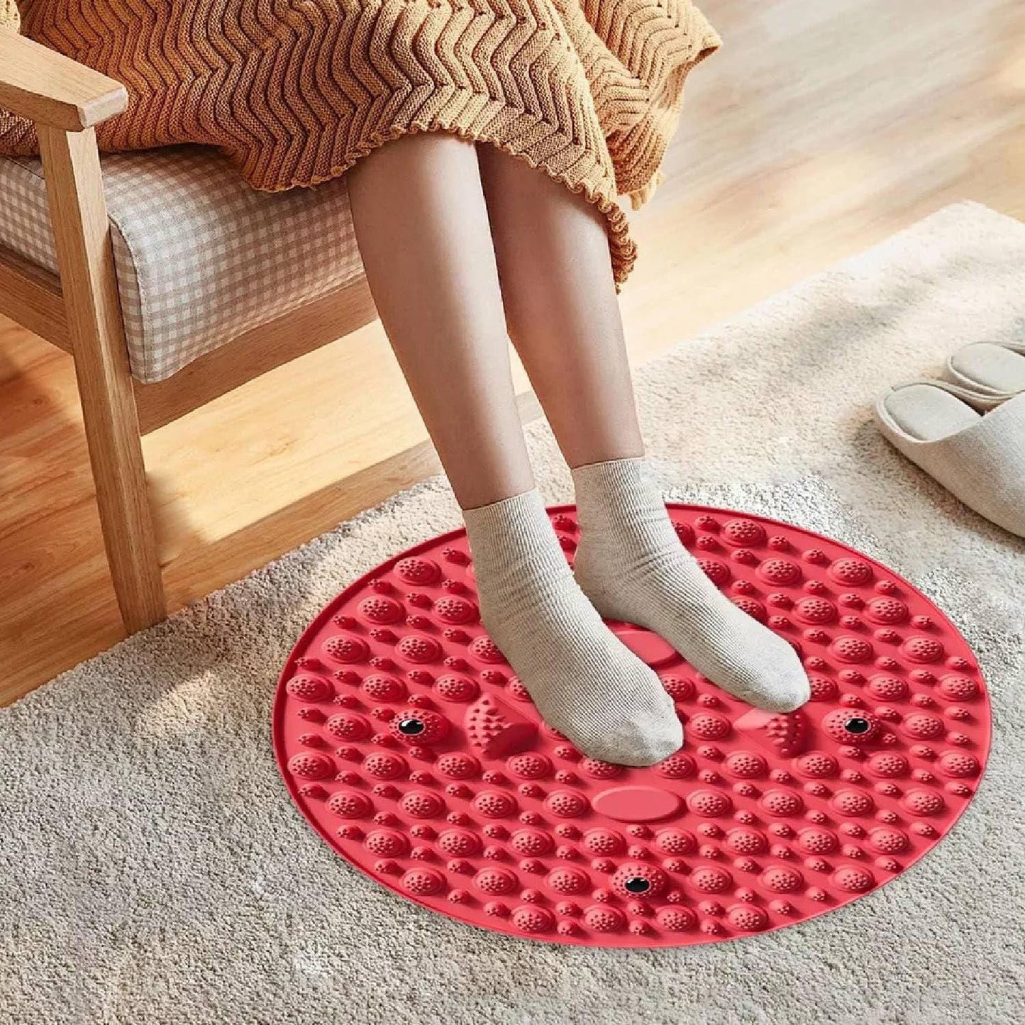 Person using a red silicone foot massage pad with textured surface for foot relaxation at home