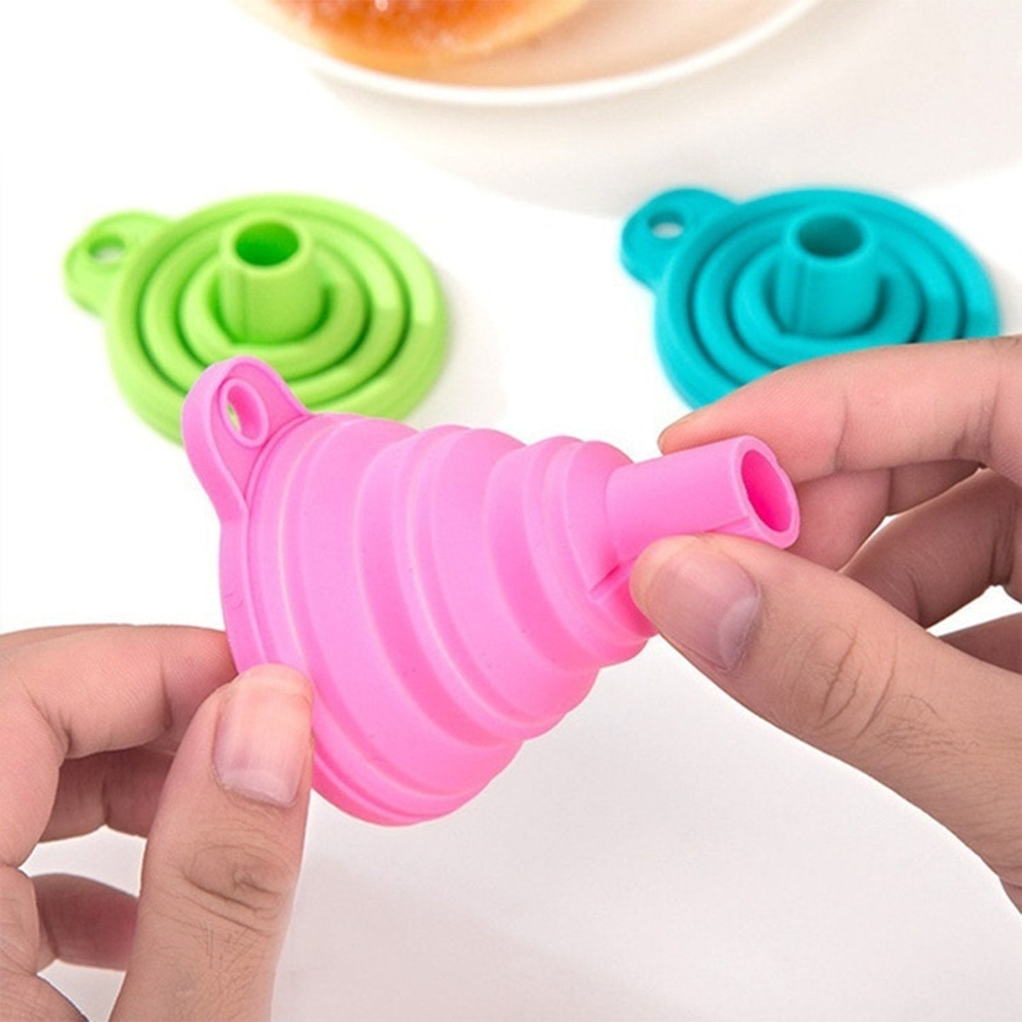 Pink silicone kitchen funnel with collapsible design for easy storage and pouring