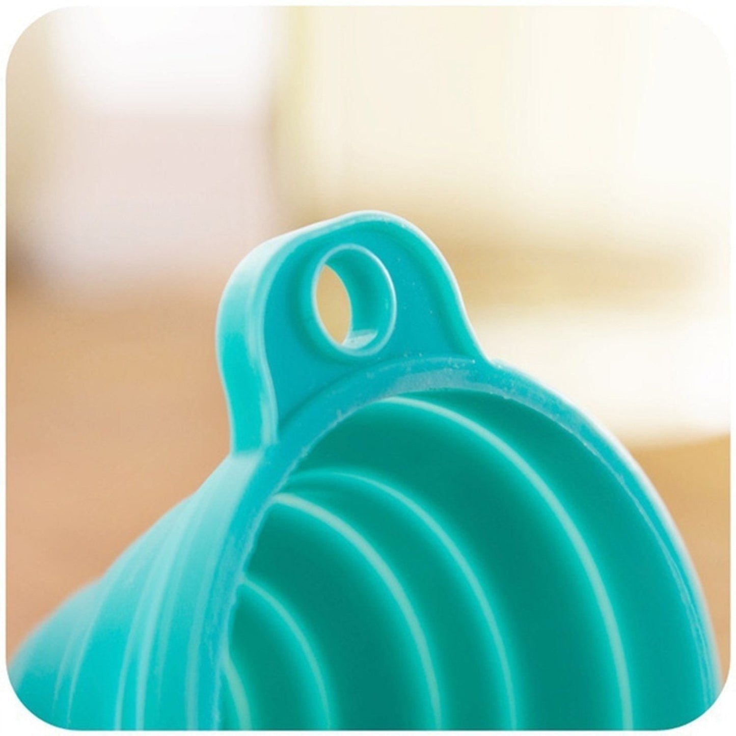 Bright teal silicone kitchen funnel with a convenient hanging hole for easy storage