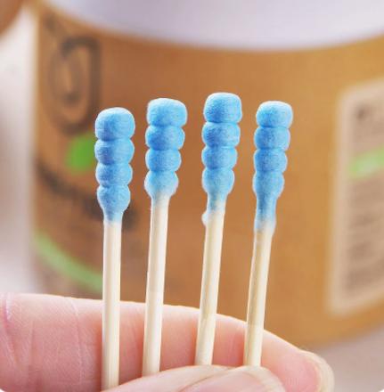 Close-up of soft wood stick cotton swabs with blue cotton tips held in hand by The Gir Farmer