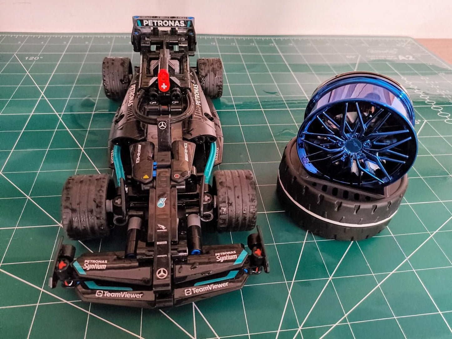 Detailed model of a racing car with a blue wheel next to it, featuring a solar powered car air freshener