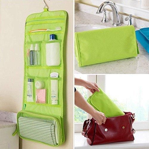 Green travel makeup organizer bag with multiple compartments hanging and being packed into a red handbag