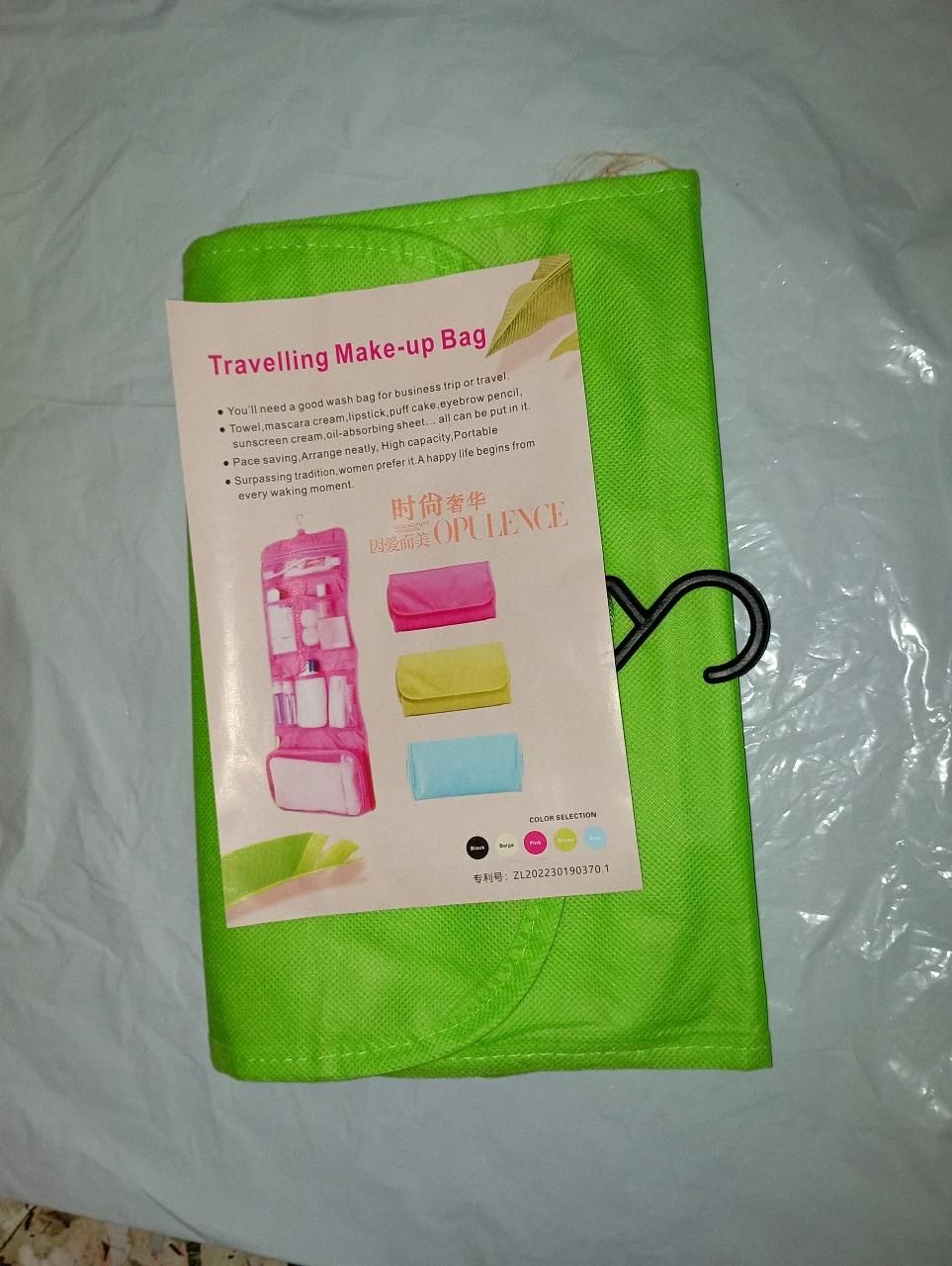 THE GIR FARMER green travel makeup organizer bag folded with label showing multiple colors