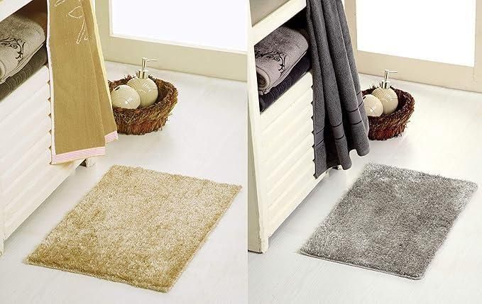 Beige and gray soft plush anti slip door mats placed on white floor near towels and decorative baskets