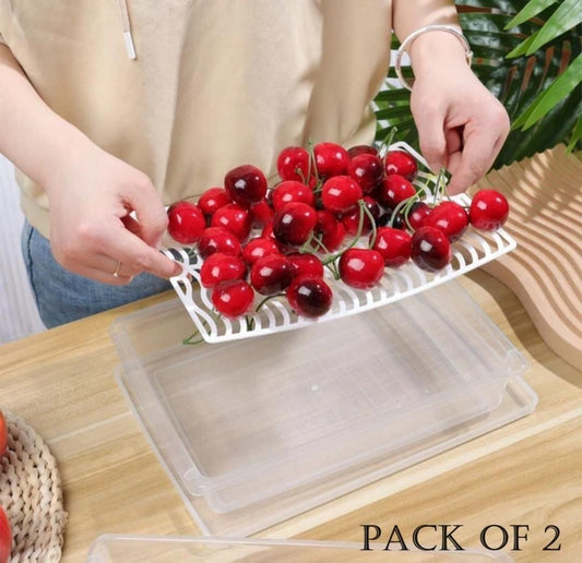 Clear plastic fruit and vegetable containers with a white tray holding fresh cherries over the container
