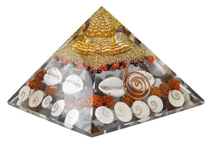 Crystal wealth pyramid for home with seashells, copper coil, and gold detailing for energy healing