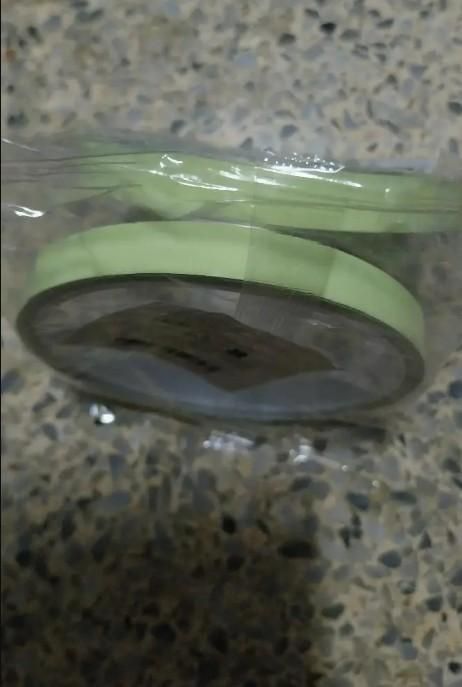 The Gir Farmer glow in the dark safety tape roll wrapped in clear plastic on a textured surface