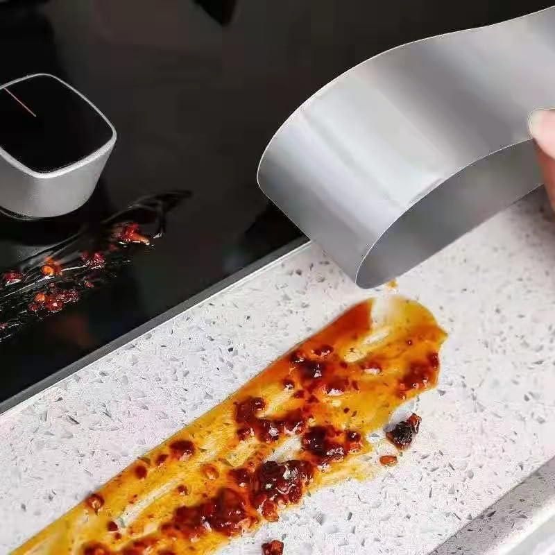 High temperature resistant aluminum tape being used to clean sticky sauce from a kitchen countertop