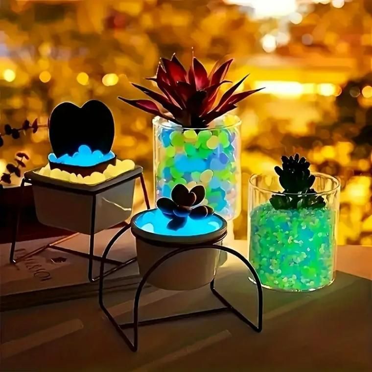 Mixed color glow stones for pathways glowing under plants in glass and metal containers