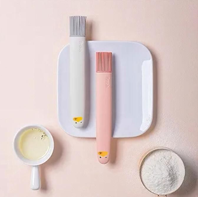 THE GIR FARMER silicone pastry brush set in gray and pink with soft bristles on white plate with baking ingredients