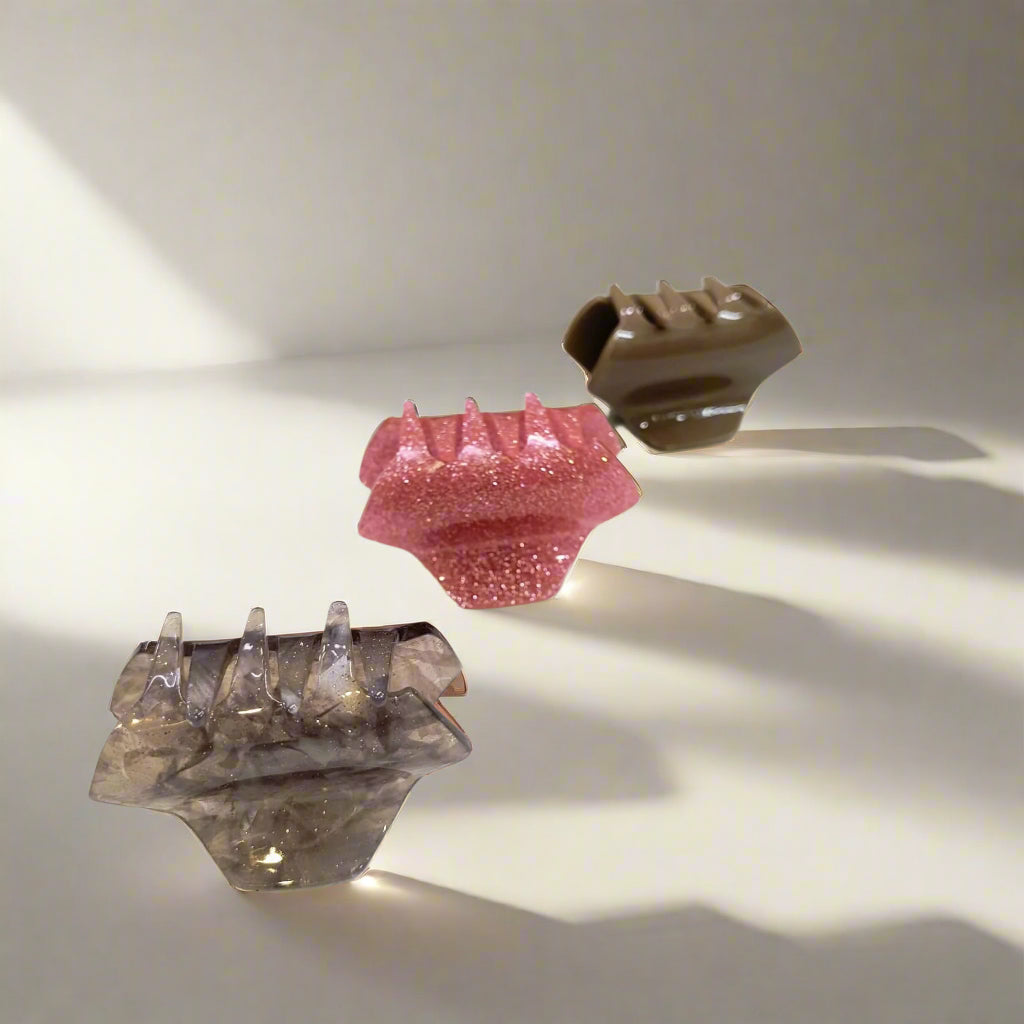 Set of small hair claw clips for women in glitter pink, brown, and translucent gray colors