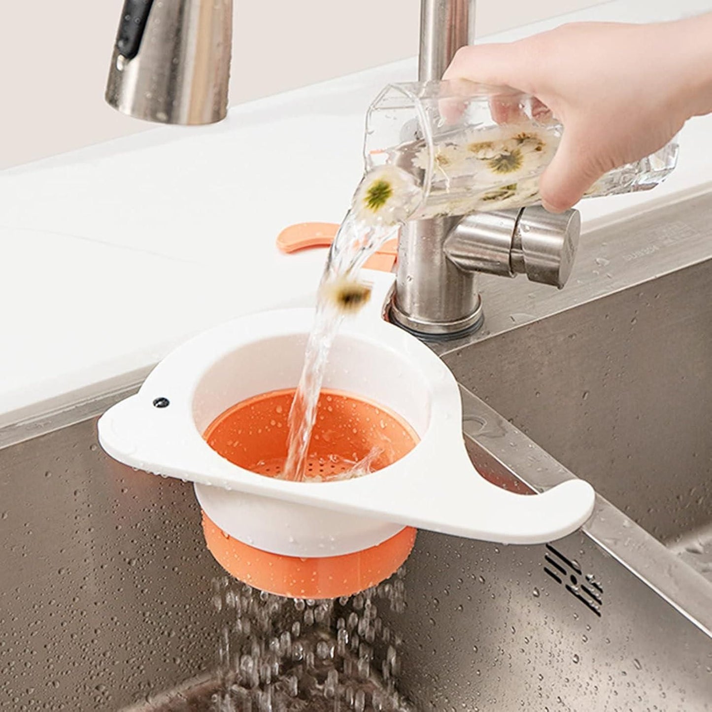 Whale drain basket for kitchen in white and orange installed on sink draining water from a glass
