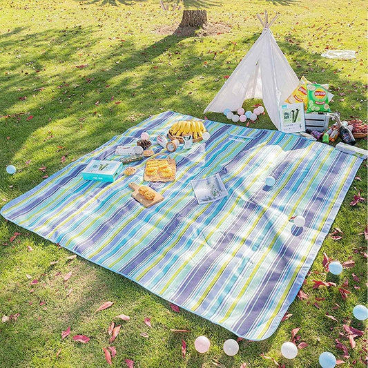 Large striped washable picnic mat spread out on grass, perfect for outdoor gatherings and meals