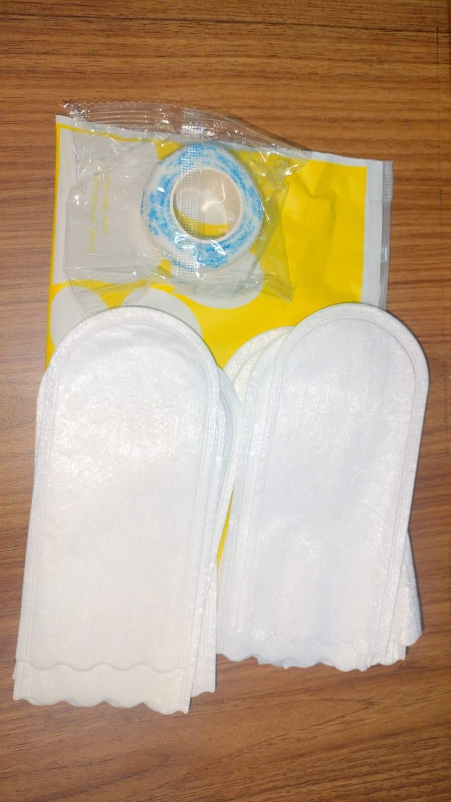 White waterproof dog paw covers by THE GIR FARMER laid flat on wooden surface with yellow packaging