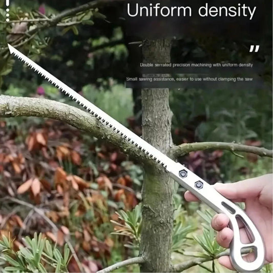 Wood pruning saw with serrated blade cutting a tree branch held by hand in outdoor garden