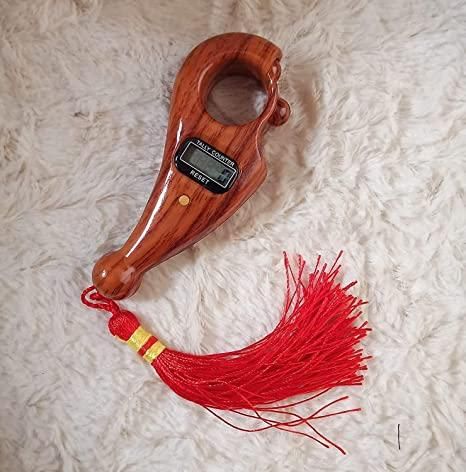 Wooden handheld digital tally number counter with finger ring and red tassel on plush background