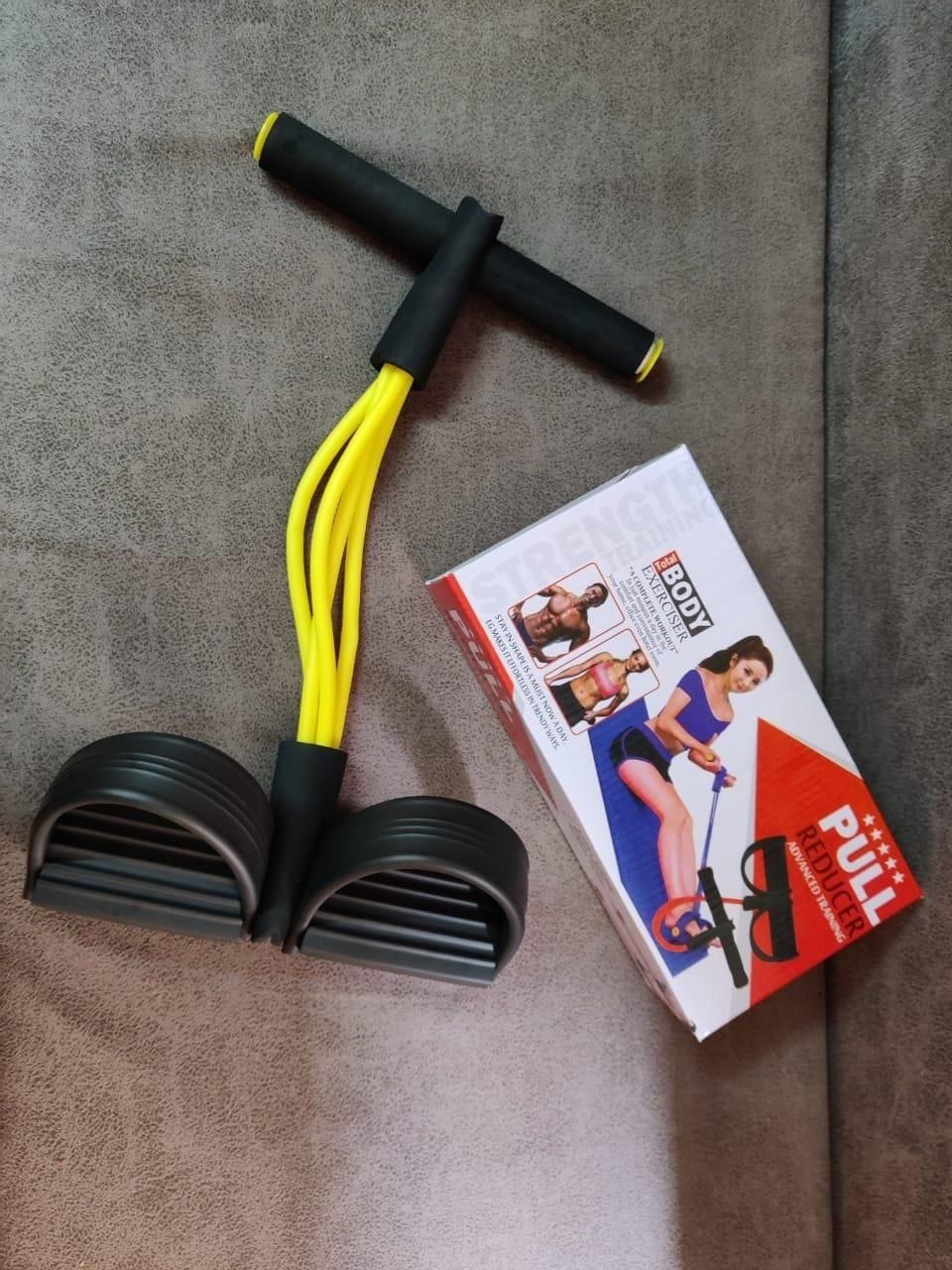 Black and yellow yoga stretch resistance puller with foam handles and foot pedals next to product box