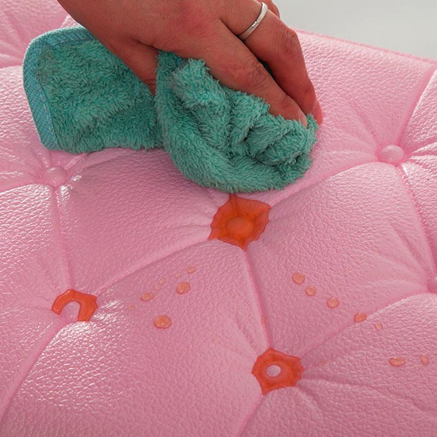 Person cleaning pink 3D adhesive wallpaper with a cloth to maintain its stylish appearance