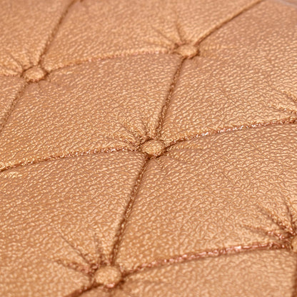 Close-up of textured 3D adhesive wallpaper in a warm gold color for home decor