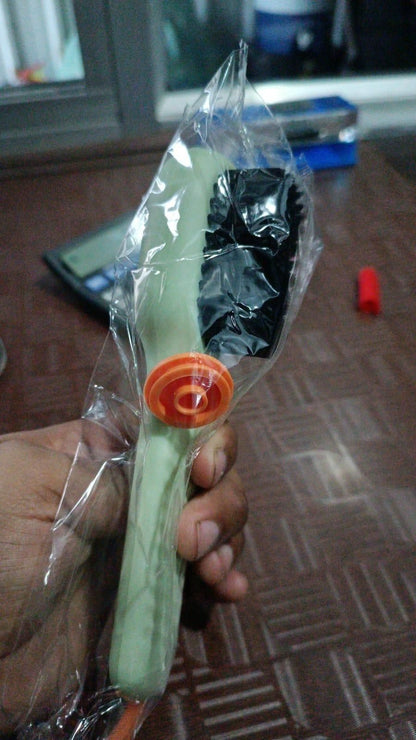 Multifunctional shoe brush with green handle and black bristles in clear plastic packaging