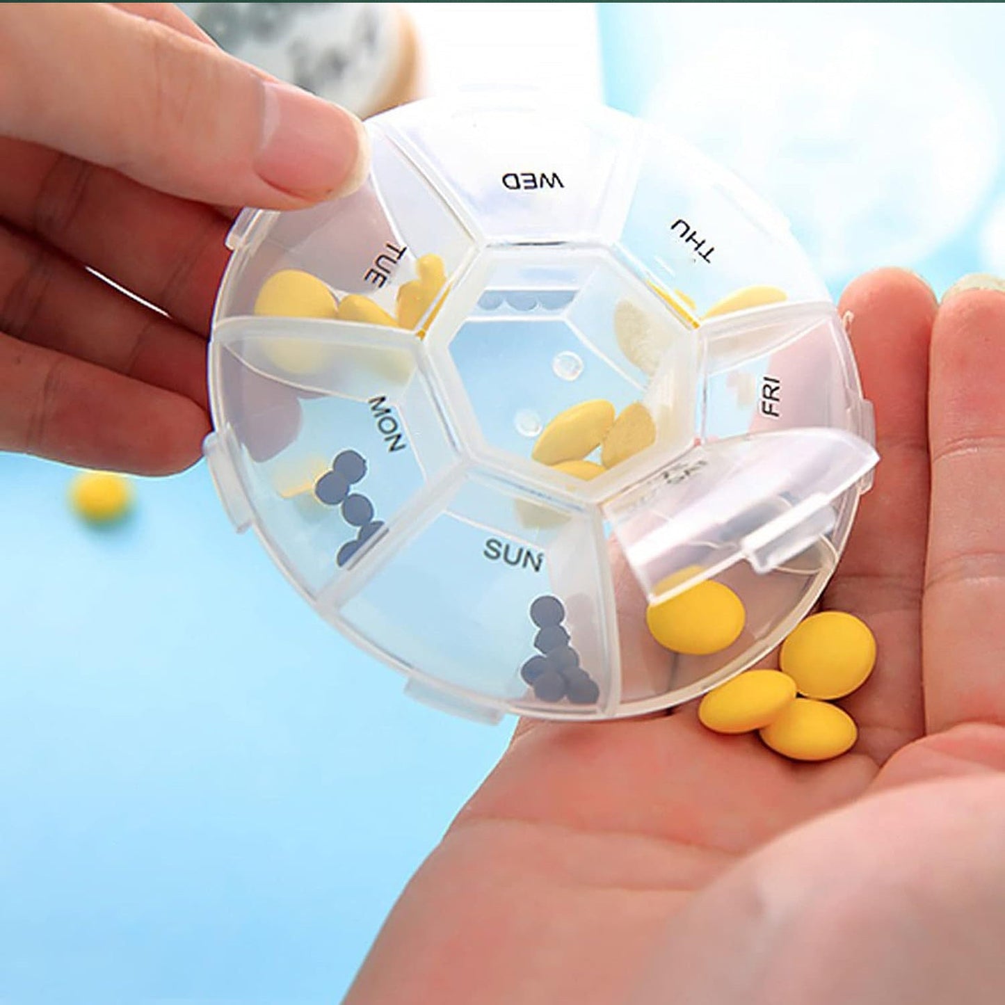 7 day pill organizer with compartments for each day, shown being held in a hand