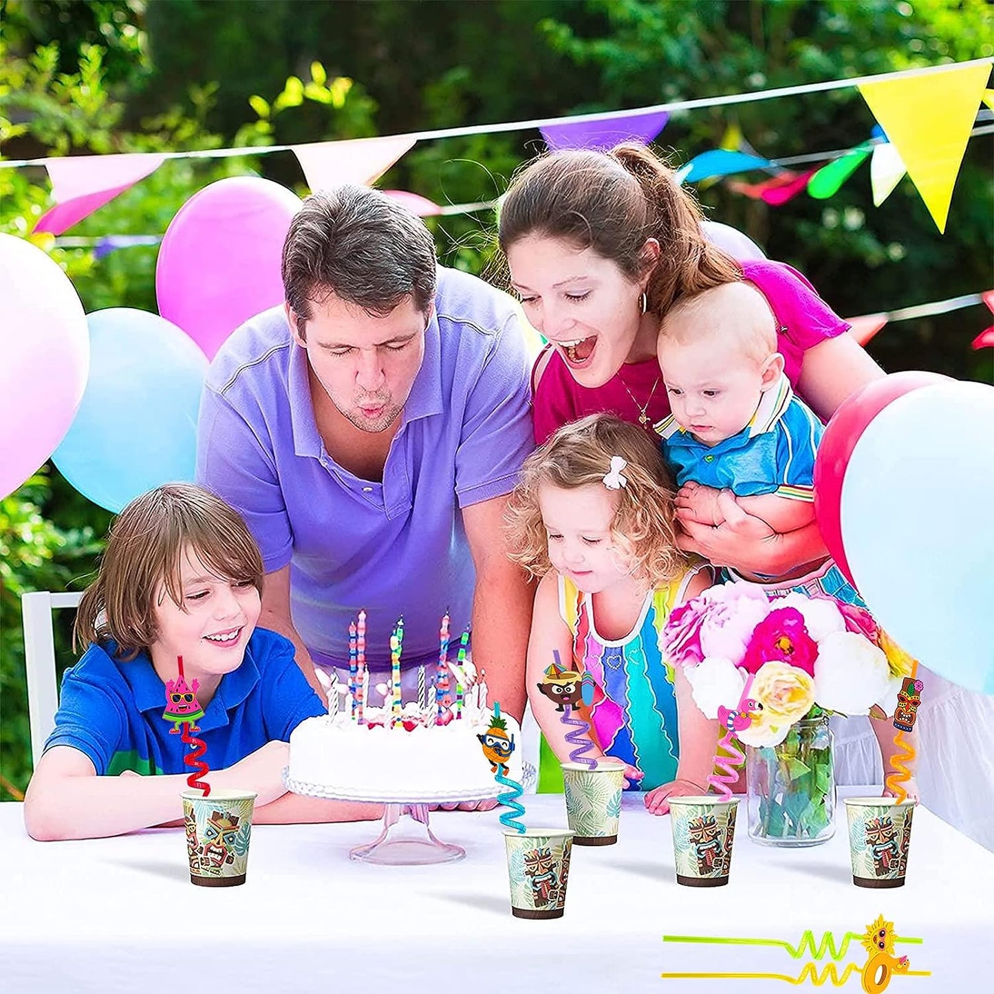 Colorful reusable plastic drinking straws in festive cups during a birthday celebration with family