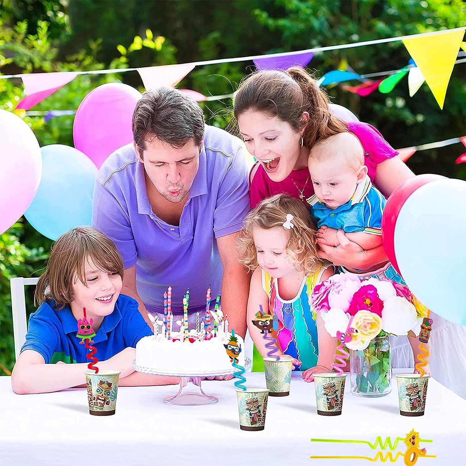 Colorful reusable plastic drinking straws in festive cups during a birthday celebration with family