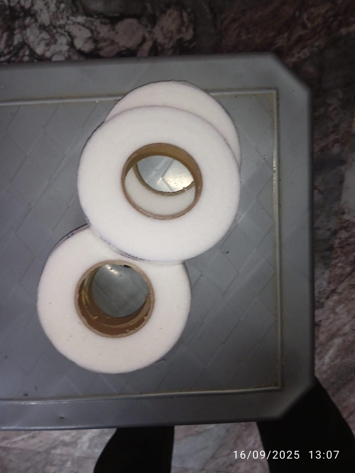 Three rolls of adhesive fabric fusion tape displayed on a textured surface for crafting projects
