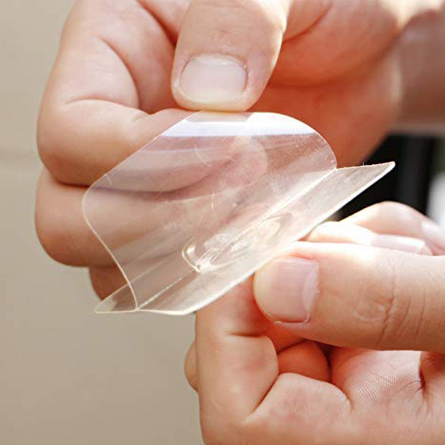Transparent adhesive screw wall hook being applied for easy hanging solutions