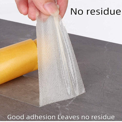Hand peeling transparent mesh heavy duty carpet adhesive tape from floor next to yellow backing roll no residue