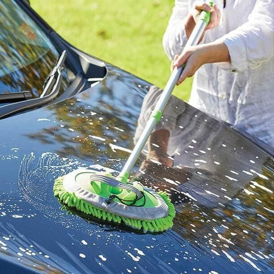 Adjustable mop for outdoor use cleaning car hood with soap suds on a sunny day