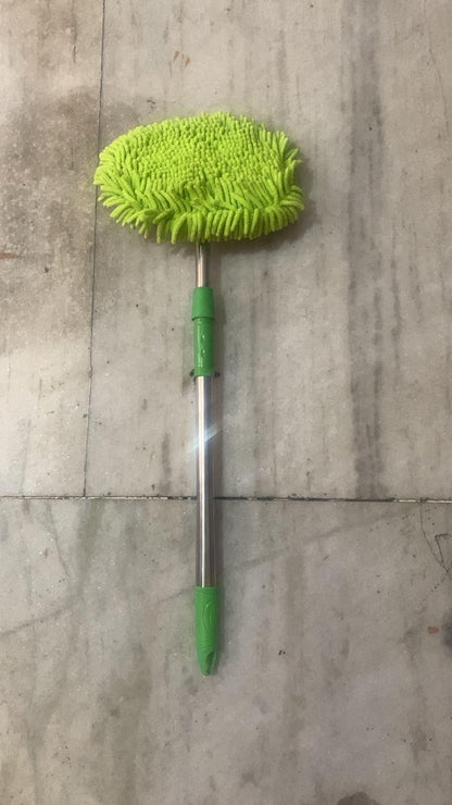 Green microfiber adjustable mop for outdoor use with extendable metal handle on tiled floor