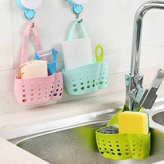 Adjustable sink caddy basket in pink and green for convenient kitchen organization and easy access