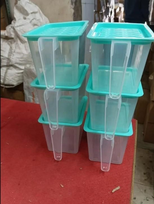 Set of airtight food storage containers for refrigerator with teal lids stacked on red surface