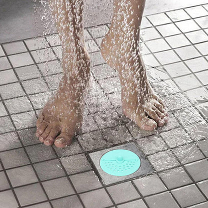 Anti-odor round drain cover in a shower, blocking hair and odors while allowing water flow