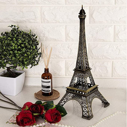 Antique Eiffel Tower statue on a table with roses and decorative plant for home improvement decor
