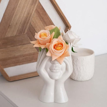 Artistic hand face vase for home decor filled with peach and white roses and greenery