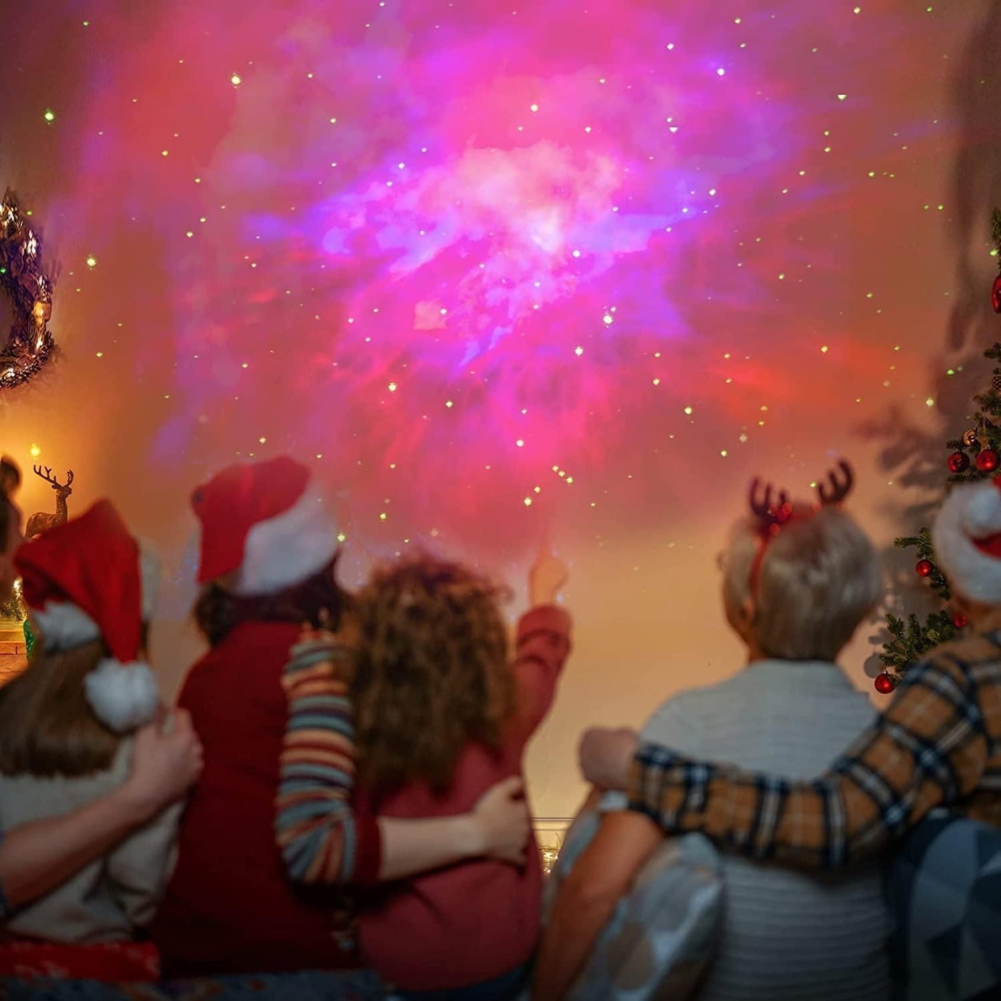 People enjoying a festive gathering illuminated by the astronaut galaxy projector creating a colorful starry sky