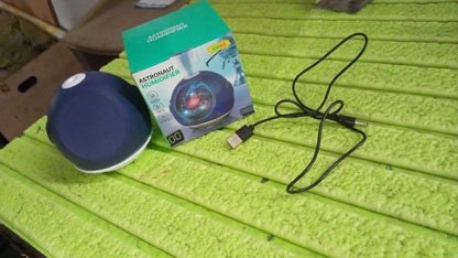 Your Brand astronaut humidifier for home in blue with box and USB cable on a bright green surface