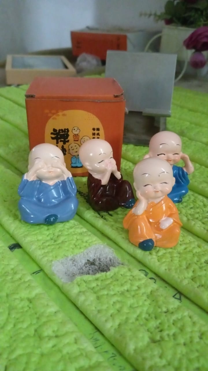Baby Buddha showpiece set featuring four colorful ceramic figurines in various poses with a decorative box
