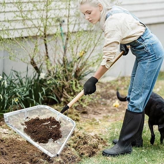 Woman using a garden shovel for soil lifting in a backyard, ideal for gardening tasks