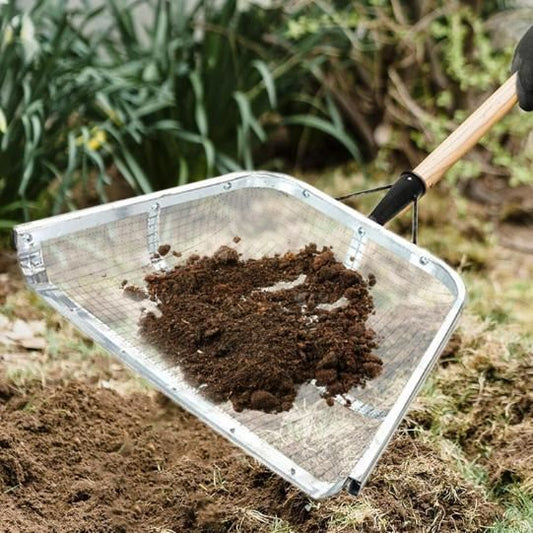 Durable metal shovel lifting soil in a garden, ideal as the best shovel for soil lifting