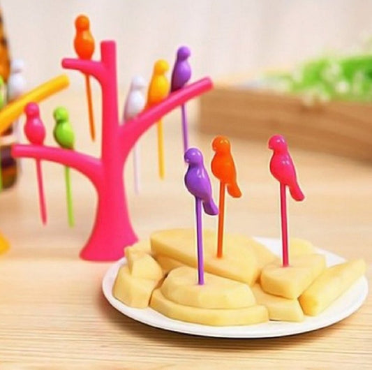Colorful bird fruit forks for kids displayed on a tree with fruits for fun dining