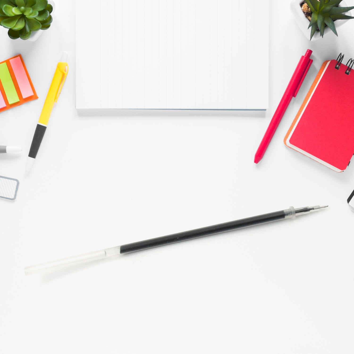 Black pen refill for smooth writing, surrounded by office essentials like notepads and highlighters